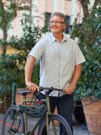 Man walking bike through Colorado town, symbolizing calm and renewal through virtual anxiety therapy