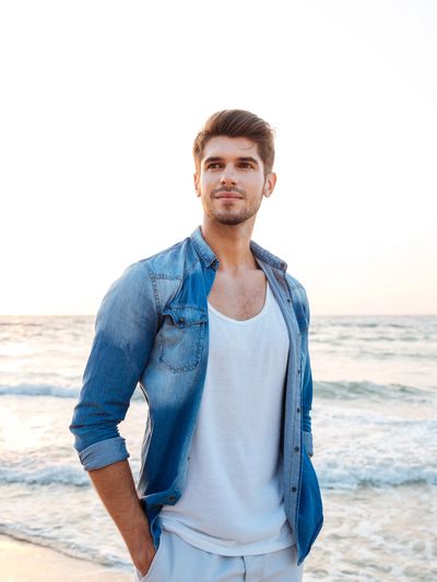 Smiling young man on Florida beach feeling relief after  depression counseling session.

