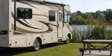 Waterfront grass RV sites with picnic table and lake view.