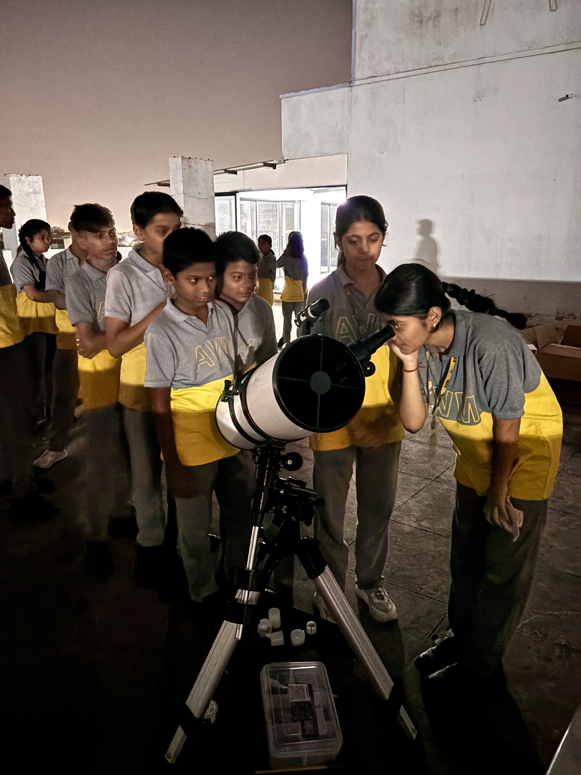 Students observing the sky through a telescope