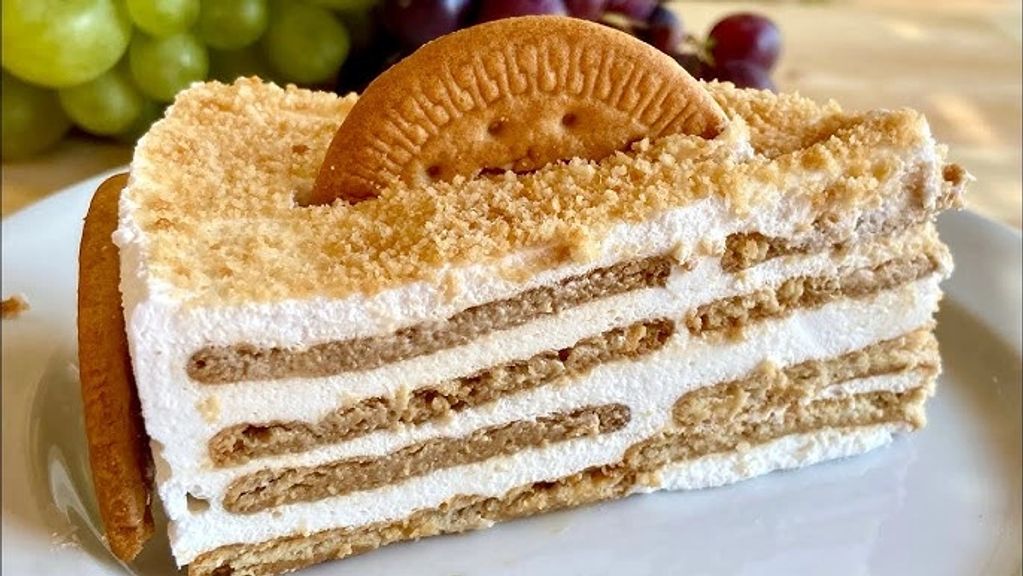 A slice of layered biscuit and cream dessert on a white plate.