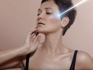 Woman receiving a facial laser treatment on her cheek.