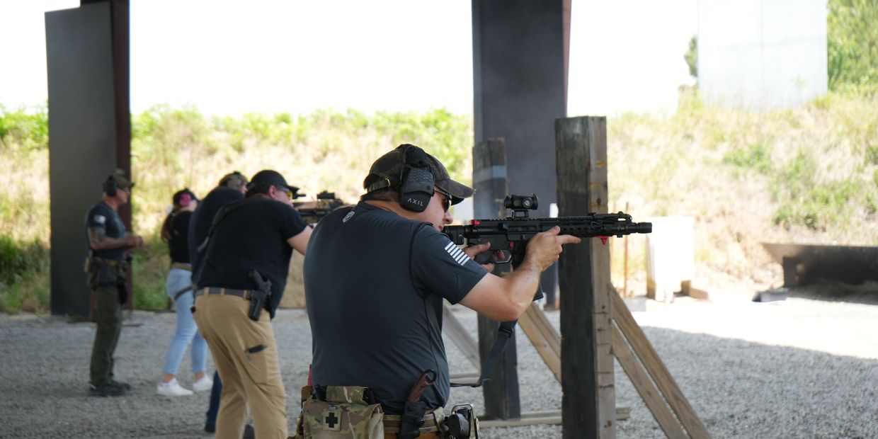 Group of people at a shooting range practicing firearm skills.