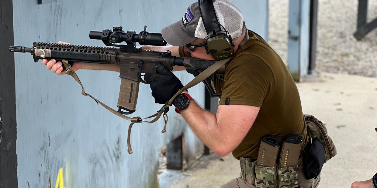 Man aiming rifle at shooting range.
