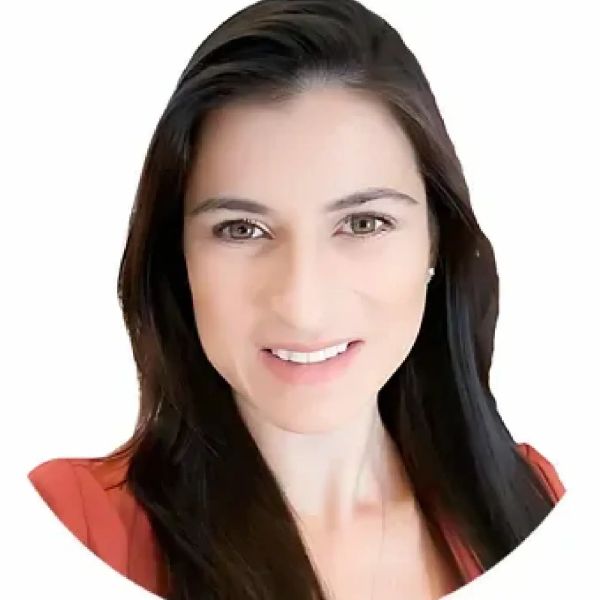 Woman with long dark hair and a friendly smile wearing a red top.