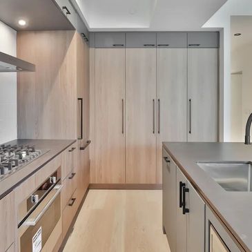 Modern residential kitchen in Sunrise, FL. wood cabinetry and black fixtures by M&M Renovations.