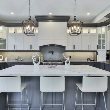 Architectural millwork and modern kitchen renovation with dual pendant lighting and grey cabinets.