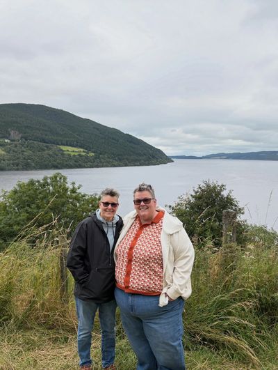 Couple smiling in front of a loch 