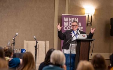 A speaker passionately addresses an audience at a conference.