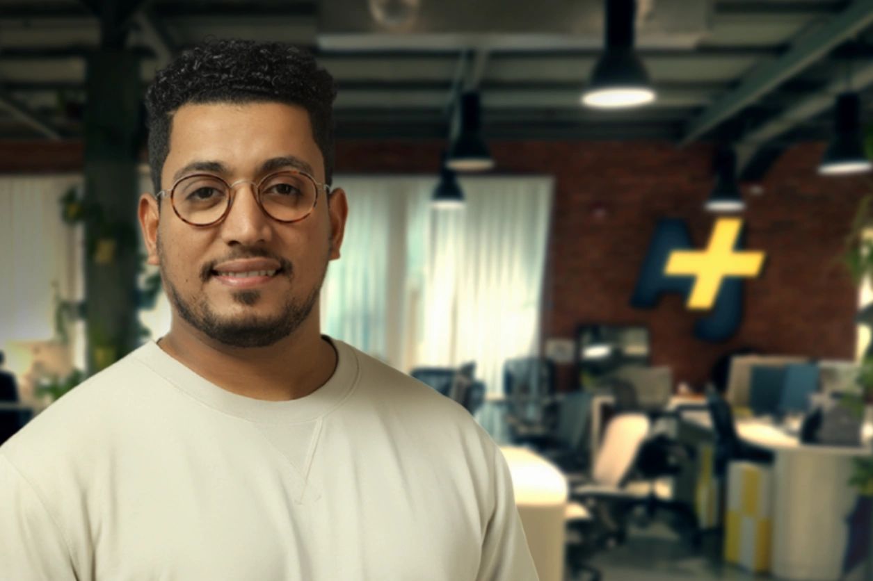 Man smiling in a modern office space.