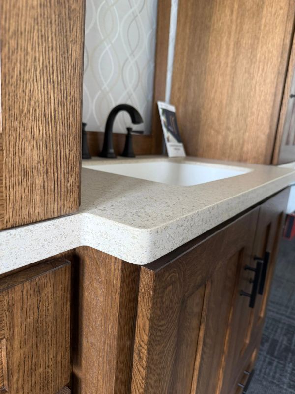 bathroom vanity with solid surface countertop and black faucet