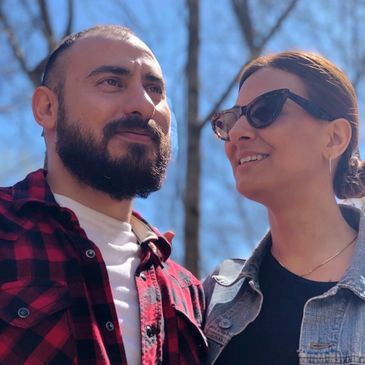 A man and woman enjoying a sunny day outdoors, smiling and looking at each other.