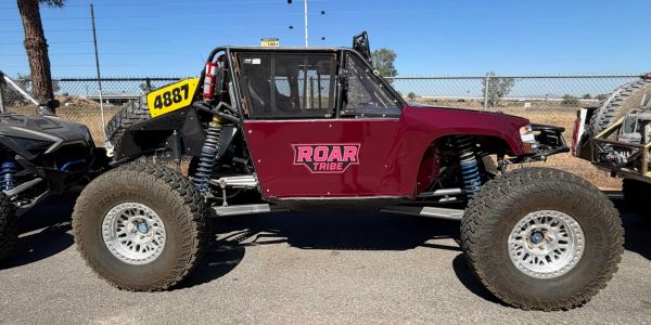 Off-road vehicle with "ROAR TRIBE" decal and large tires.