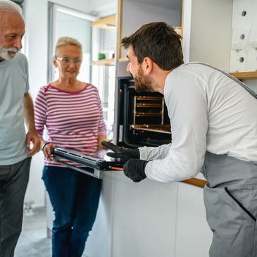 Reparateur d'electromenager qui montre a des clients leur four