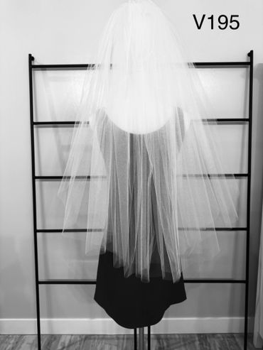 White bridal veil displayed on a mannequin against a black rack.