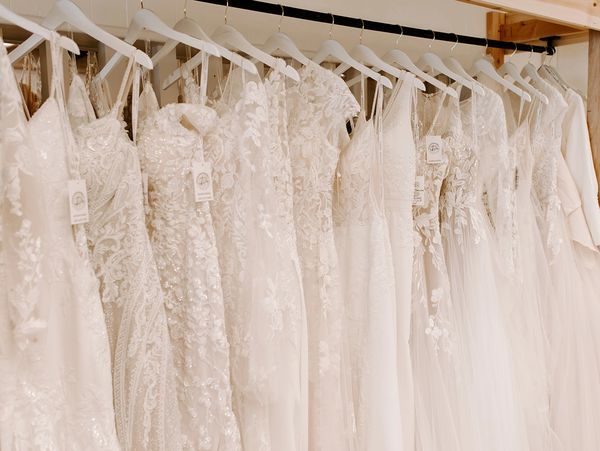 A row of elegant white wedding dresses hanging on a rack.