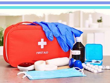 A first aid kit with medical supplies including gloves, mask, and medication.