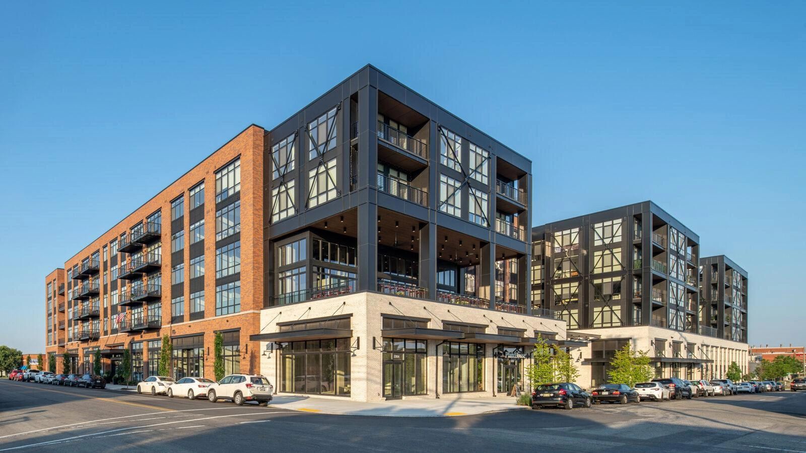 Modern mixed-use building with brick and black metal elements.