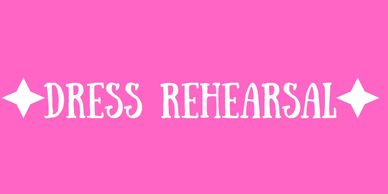 Pink sign with white text saying 'DRESS REHEARSAL'.