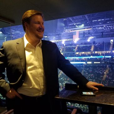 Man in suit smiling at an event venue.