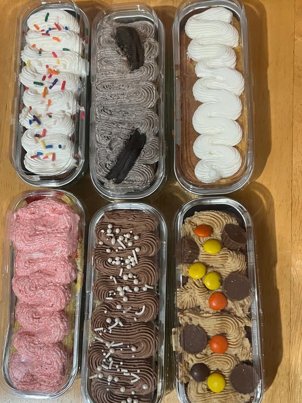 Six decorated dessert trays with various frosting and toppings.