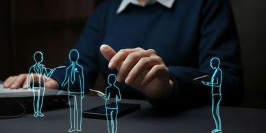 Person interacting with holographic business figures above a desk.