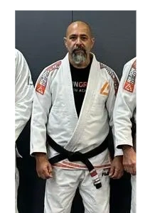 Man in Brazilian Jiu-Jitsu gi with a black belt.
