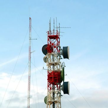 Tall communication towers against a blue sky.