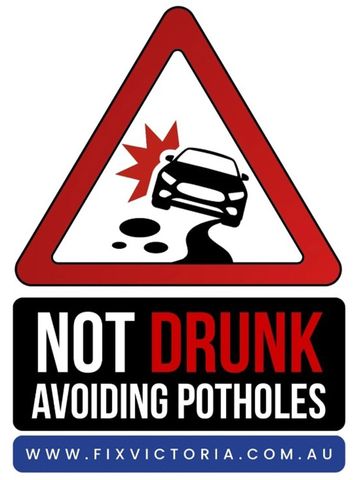 Warning sign about avoiding potholes while driving.