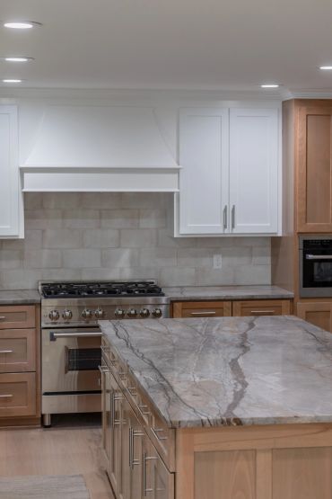 Modern kitchen with marble countertop and stainless steel oven.