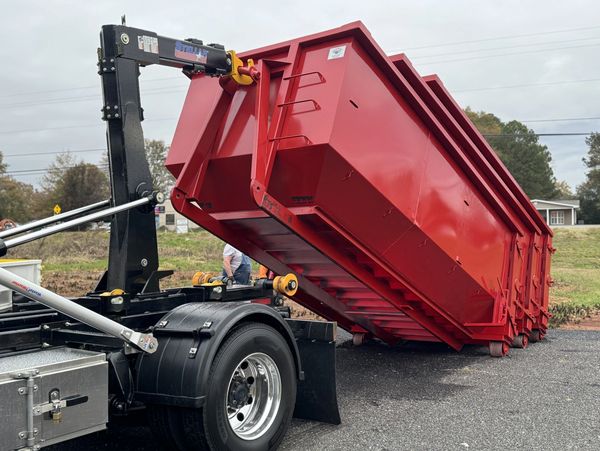 Stellar hooklift system dropping off heavy-duty red dumpster container
