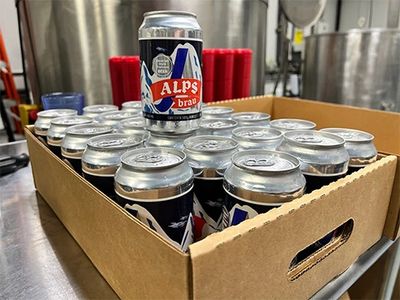 Case of new beer with one can on top for visibility