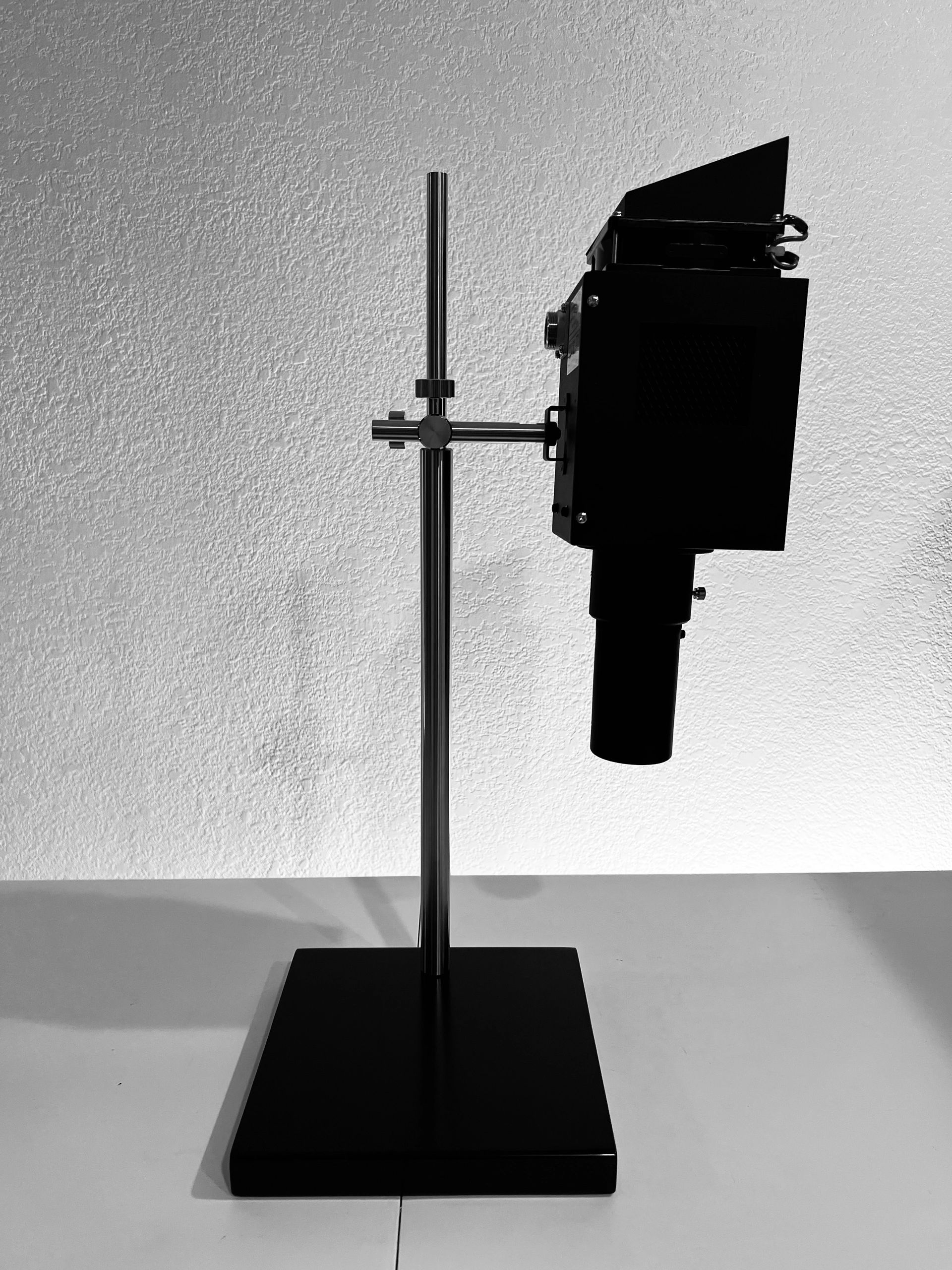 Stack of books next to pencils in a holder and a camera.