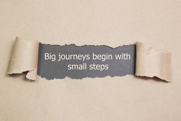 A message revealed underneath brown paper which says Big journeys begin with small steps
