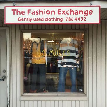 Storefront window of The Fashion Exchange with mannequins and 'Go Mules' sign.
