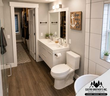 Modern bathroom with double sinks, wooden flooring, and a walk-in closet.