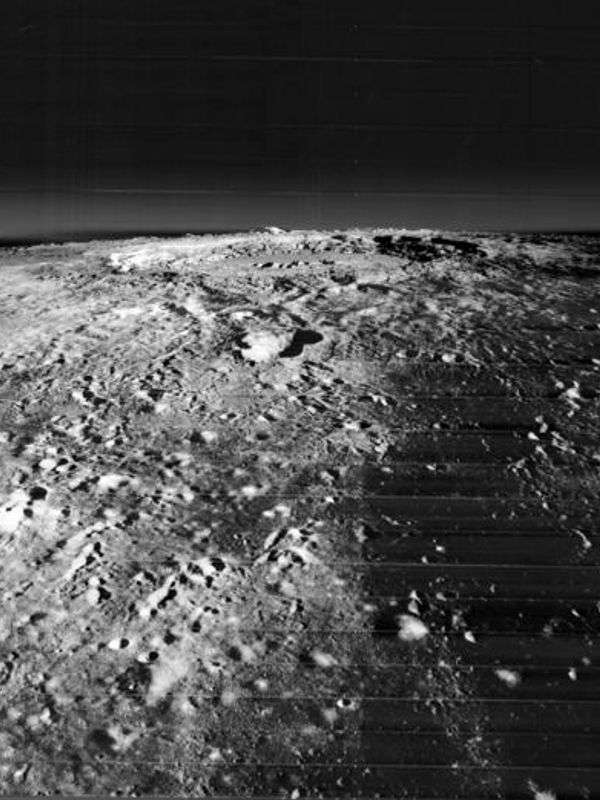 Black and white image of a cratered moon surface.