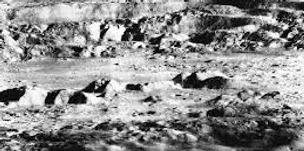 Early black and white photo of the Moon's surface with craters.