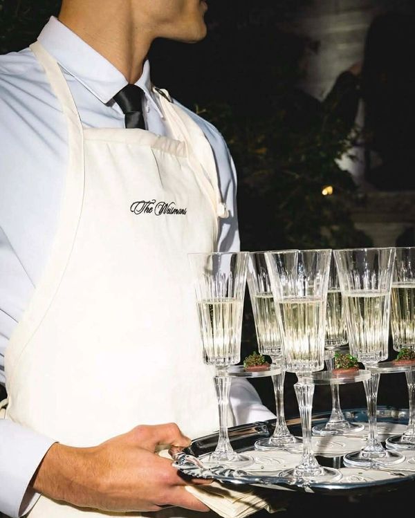 Waiter holding a tray of champagne glasses at an event.