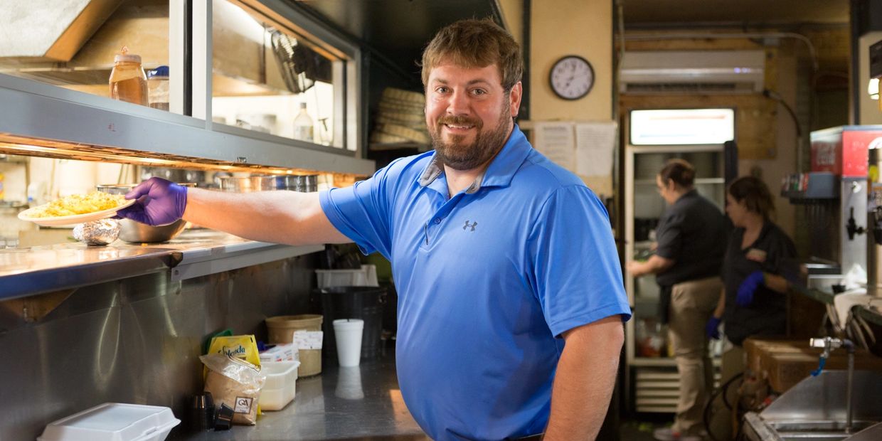 A man smiling and working in a store