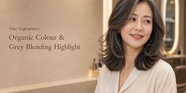 Mature woman with grey blending highlights on her hair.