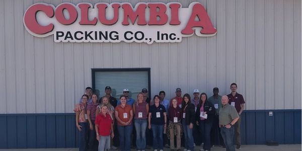 Group photo outside Columbia Packing Co., Inc. building.