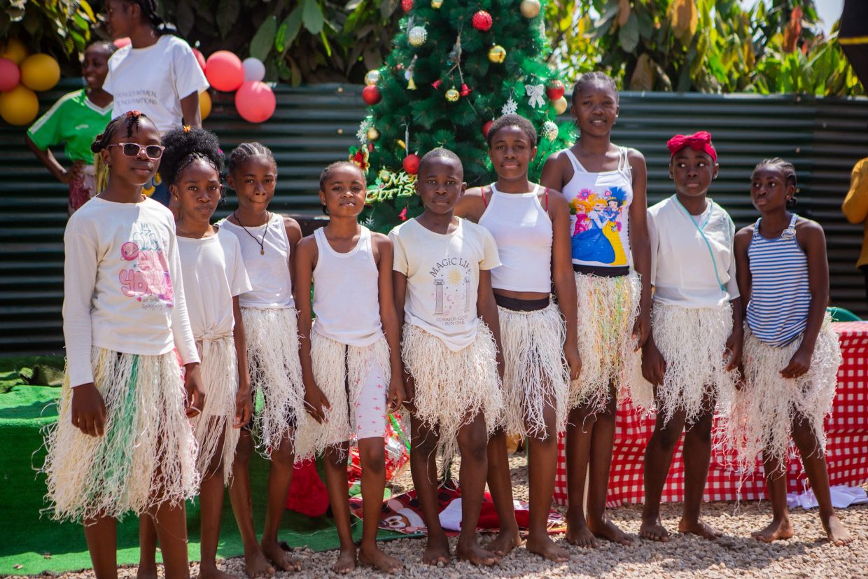 Group of children in festive attire posing outdoors.