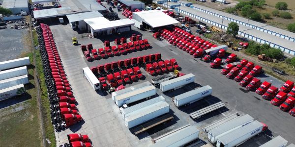 Aerial view of red trucks and trailers parked in a lot.