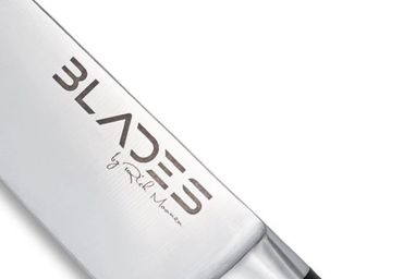 Close-up of a kitchen knife blade with the brand name 'BLADES' and signature 'by Rich Morrow'.