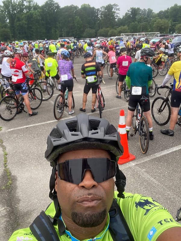Cyclist taking a selfie at a large cycling event.