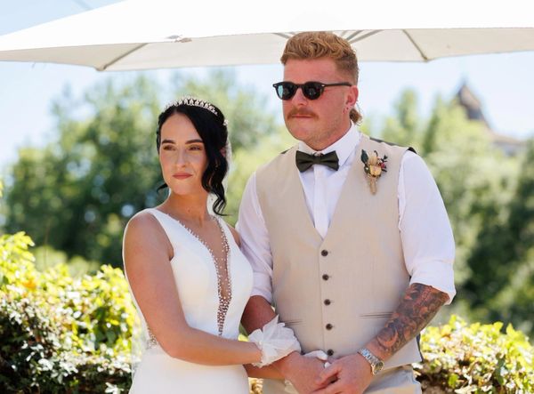 Bride and groom standing together outdoors on their wedding day.