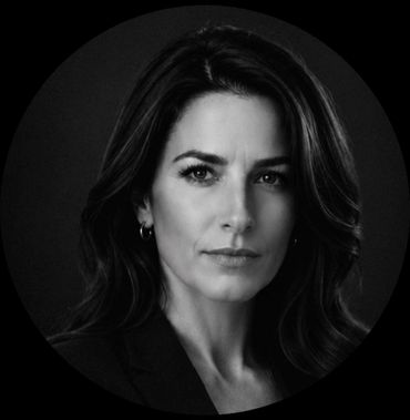 Black and white portrait of a serious woman with long hair and a confident gaze.
