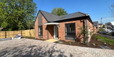 Newly built brick house with a paved driveway.