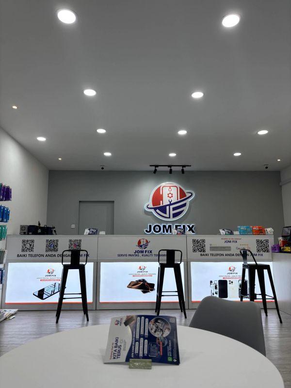 Modern phone repair shop interior with stools and bright lighting.